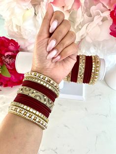 If you are looking for the maroon red and gold bangle set of your dreams, trust me when I say here it is! A STUNNING combination of maroon red bangles artistically placed between various styles of gold bangles, including gold mirror bangles, a center gold filigree bangle and pearl bangles on either end. This is a full set of bangles, more enough to wear on both arms as pictured. LIMITED STOCK REMAINING - this set is a limited style in my shop. If you have your heart set on it, please do purchase before it sells out.   One set is good for both arms.  If you are in between sizes, I would recommend sizing up. A larger size is easier to fit into and the difference in the appearance of the bangles on your arm will be unnoticeable.  Shop more Indian bangle sets here: https://www.etsy.com/ca/shop Luxury Red Bangle For Formal Occasions, Luxury Red Festive Bangle, Maroon Bangles Set, Luxury Red Bangle For Anniversary, Red Bollywood Bracelets For Wedding, Red Bollywood Bracelets For Celebration, Red Bollywood Bangle For Party, Red Bollywood Festive Bracelet, Red Bollywood Party Bangle