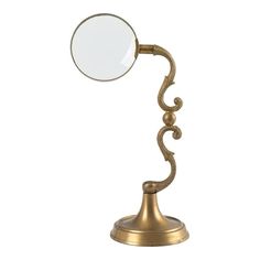 an antique brass desk lamp with a magnifying glass on it's side