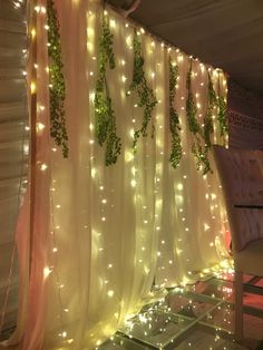 the curtain is covered with lights and ivys hanging on it's side wall