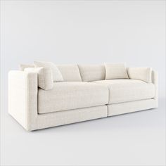 a white couch with pillows sitting on top of it