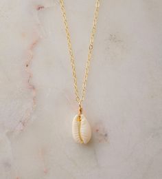 "Unleash your inner beach goddess with our Natural White Cowrie Shell Necklace! Handcrafted with a creamy-white cowrie shell, this piece is more than just a necklace--it's a conversation starter, a part of the ocean, a symbol of strength and prosperity. Perfect to uplift any outfit and designed to transport you to sunny shores, this necklace is sure give you summer vibes all year round.  We hand-make each necklace to order with a natural Cowrie shell that's set onto your choice of a sterling sil White Ocean-inspired Charm Necklace For Gift, Ocean-inspired White Charm Necklace As Gift, Ocean-inspired White Charm Necklace Gift, Dainty Shell Charm Necklace For Beach, White Shell Charm Necklace Gift, Dainty Strand Jewelry For The Beach, Dainty Strand Jewelry For Beach, White Jewelry For Beach Season Gift, Dainty Strand Beach Jewelry