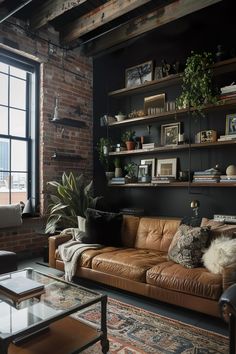 Cozy living area with a tan leather sofa, brick walls, and a mix of plants and decor on shelves. Rustic house interior design with a city view. Dramatic Living Room, Dark Living Room Ideas, Eclectic Garden, Black Accent Wall, Feminine Living Room, Masculine Living Rooms, Moody Living Room, Snug Room, Black Accent Walls