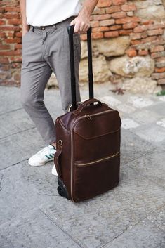 Upgrade your travel experience with our Handmade Italian Leather Rolling Suitcase, a perfect blend of luxury and functionality. Crafted from the finest Tuscan vacchetta leather, this rolling suitcase showcases the rich heritage and artisanal skill of Montepulciano. Designed for both men and women, this carry-on bag combines elegance with practicality, making it an ideal choice for both business trips and vacations. Features: ◉ Premium Material: Made from 100% genuine Tuscan vacchetta leather, ce Luxury Cognac Briefcase For Travel, Brown Leather-lined Luggage For Travel, Classic Leather Travel Accessories With Luggage Sleeve, Luxury Cognac Laptop Bag For Travel, Luxury Travel Laptop Bag In Cognac, Cognac Weekender Bag For Travel, Brown Leather Lined Travel Bag, Classic Briefcase With Luggage Sleeve For Travel, Brown Luggage With Leather Lining For Trips