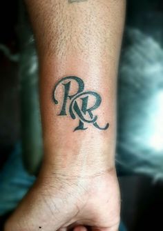 a man's arm with a tattoo on it and the letter r in black ink