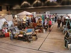 a large room filled with lots of furniture and people looking at them in the distance