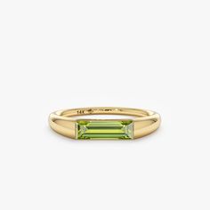 Capture the essence of August with the Natural Peridot Ring, a radiant symbol of summer's warmth and vitality. Crafted in your choice of 14k or 18k solid gold, this ring showcases a vibrant green peridot, the birthstone for August, elegantly displayed in a modern channel setting. Its understated design and timeless beauty make it a perfect addition to any jewelry collection. - Handmade - Solid Gold - Natural Peridot - Total Peridot Carat Weight: 0.93 ctw - Height of the Setting: 2.9 mm - Ring Thickness: 3.47 mm 🛠 Your Sarah Elise piece is handcrafted with care! Ready-to-ship items go out within 3 business days. Made-to-order pieces typically take 7-10 business days to create. If you need something sooner, please contact us - we'll see if we can make it happen! For estimated shipping dates Modern Yellow Gold Baguette-cut Emerald Ring, Ring Baguette, Solid Gold Bracelet, Channel Setting, August Birthstone, Beautiful Gift Wrapping, Initial Ring, Peridot Ring, Solid Gold Rings