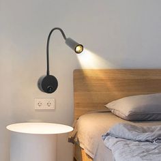 a bed room with a neatly made bed and a lamp on the nightstand next to it