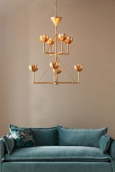 a living room with a blue couch and gold chandelier