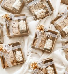 small boxes filled with marshmallows on top of a white cloth covered bed