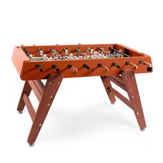 an orange foosball table sitting on top of a white floor with two legs