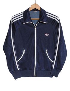 Vintage 1970's Adidas track jacket in a navy blue colour. Trademark three stripes down the sleeves. Trefoil sewn on the front. Opti zips. Elasticated waist and cuffs. Curved zip pockets. Made from a polyester cupro blend. Label reads 40. Condition: Excellent vintage condition. Chest: 36in Length: 24in Inside sleeve: 18in More vintage clothing on our website www.brickvintage.com Blue Track Jacket, Adidas Navy Blue, Adidas Navy, Adidas Vintage, Adidas Track Jacket, Adidas Track, Navy Blue Color, Track Jacket, Track Jackets