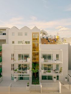 an apartment building with several balconies and plants on the top floor in front of it