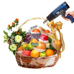 a basket filled with lots of different types of fruit next to a blow dryer