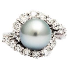 A Silver gray Tahitian pearl and white diamonds ring from the collection "Purity Di Perle" from FERRUCCI ., in a modern swirl design to compliment the delicate unique class of a sophisticated woman,Cherished as symbols of purity and perfection, elegance and affluence, Made in Italy Entirely made in 18k white gold, Size 6.75 Diamond total carat weight of 1.72 carat weight Silver Gray Tahitian Pearl 10.1 carat weight Diamond Pearl Ring, Tahitian Pearl Ring, Pearl Cocktail Ring, Pearl Wedding Ring, Fine Pearl Jewelry, Victorian Engagement Rings, Tahitian Black Pearls, Pearl And Diamond Ring, Bracelet Love