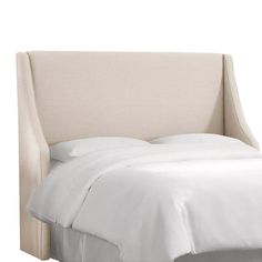 an upholstered headboard with white sheets and pillows on the bottom half of it