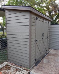 a small shed sitting next to a fence