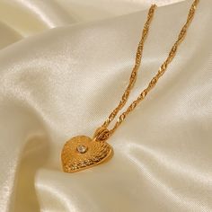 The Heart Necklace, in 18k gold plating, is an elegant symbol of love and affection. Its classic heart-shaped pendant adds a romantic touch to any look, making it perfect for everyday wear or special moments. Elegant Heart Necklace Tarnish Resistant As Gift, Gold Plated Double Heart Charm Necklace, Elegant Yellow Gold Necklace With Heart Detail, Elegant Double Heart Locket Charm Necklaces, Elegant Heart Shaped Locket Charm Necklace, Elegant Heart-shaped Locket Charm Necklace, Elegant Heart Locket Charm Necklace, Valentine's Day Gold Plated Heart Cut Necklace, Gold Heart Cut Charm Necklace