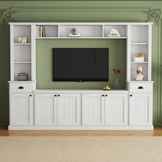 an entertainment center with white cabinets and a flat screen tv mounted on it's wall