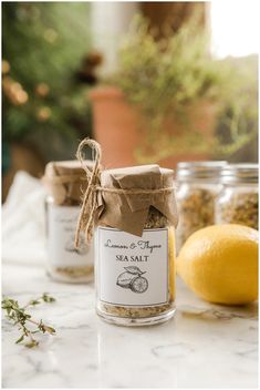 two jars filled with sea salt next to lemons