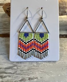 Fun summertime fringe beaded earrings! Three styles to choose from: Shimmery white AB, apricot and pale silk blue beads with silver lever back ear hooks, lime green color block triangles, and shades of purple with emerald green beads as accents beaded onto a small teardrop frame. Nickel and lead safe. Bohemian Spring Jewelry With Fringe, Spring Bohemian Jewelry With Fringe, Spring Bohemian Fringe Jewelry, Orange Tassel Jewelry For Summer, Bohemian Dangle Tassel Earrings For Spring, Bohemian Summer Dangle Tassel Earrings, Summer Bohemian Dangle Tassel Earrings, Summer Beach Tassel Earrings With Dangling Beads, Bohemian Fringe Earrings For Spring