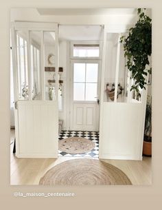 an entry way with white doors and black and white checkered rugs on the floor