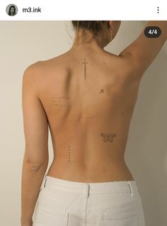 the back of a woman's body with tattoos on it