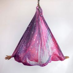 a pink and purple hammock hanging in the air with space printed on it