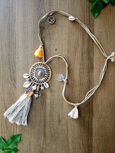 Embrace the beauty of bohemian style with this stunning handcrafted necklace. Featuring an intricate centerpiece adorned with seashells, tassels, and a blend of earthy tones, this piece evokes a free-spirited and natural vibe. The delicate details, such as charms, feathers, and beads, bring a sense of adventure and uniqueness to your look, perfect for those who love to express their individuality with their accessories." Adjustable Tassel Necklace For Festivals, Bohemian Handmade Necklaces For Summer, Handmade Bohemian Necklaces For Summer, Bohemian Long Necklace With Tassels, Bohemian Tassel Necklace For Festivals, Bohemian Multicolor Long Necklace For Festivals, Summer Festival Jewelry With Tassels, Bohemian Silver Jewelry For Vacation, Adjustable Bohemian Long Necklace With Tassels