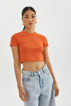 Elevate your basics with the INGA cropped t-shirt. The shortened length is perfect for a laid-back vacation atmosphere. It effortlessly pairs with various bottoms, from shorts and skirts to jeans or casual trousers, allowing you to create different looks with minimal effort. Orange Crop Top, Cropped T Shirt, Casual Trousers, Crop Tshirt, Rib Knit, Trousers, Crop Tops, Orange, T Shirt