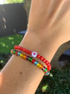 Circular red beads sealed with a heart for lasting luck in love combined with a multi color strand of glass seed beads! - Standard bracelet size is 7 inches. Please message me if you have smaller or larger wrists. Heart-shaped Colorful Beads For Gifts, Heart-shaped Tiny Beaded Bracelets For Friendship, Heart-shaped Beaded Bracelets With Tiny Beads For Friendship, Red Heart Charm Bracelet For Friendship, Gift Heart Bracelet With Colorful Round Beads, Everyday Multicolor Heart-shaped Beaded Bracelets, Red Letter Beads For Friendship, Red Bohemian Bracelets With Letter Beads, Bohemian Red Bracelets With Letter Beads