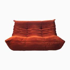 an orange couch that is sitting on the ground