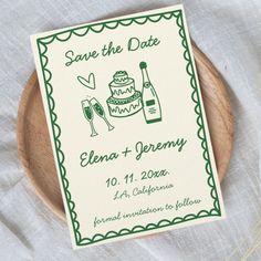 a save the date card on a wooden plate with wine glasses and cake in it