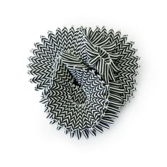 a black and white paper sculpture on top of a white surface with an abstract design