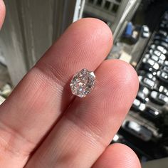 a close up of a person's hand holding a diamond