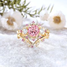 a pink and white diamond ring sitting on top of snow