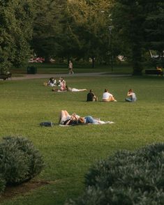 several people laying on the grass in a park