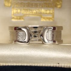 This is a beautiful ring from the luxury jewellery designer Cartier. The ring forms part of the 'Double C' collection and is an iconic and highly recognisable design. The 18ct white gold has a brushed finish in the centre and polished gold borders. Condition: Used (Very Good) Weight: 6.8 grams Ring Size: K 1/2 (50) Band Width: 6.5mm Marked: 'Cartier' '2000' '750' '50' and the serial number Box: Plain gift box Certificate: The Vintage Jeweller guarantee of authenticity If you have any questions r Elegant Diamond Cut Signet Ring For Promise, Luxury Rings With Polished Finish For Promise, Luxury White Gold Signet Promise Ring, Elegant Sterling Silver Signet Promise Ring, Luxury White Gold Engraved Promise Ring, Luxury Polished Finish Rings For Promise, Luxury Polished Promise Couple Rings, Modern Diamond Ring For Anniversary, Luxury Polished Couple Rings For Promise