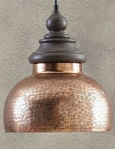 a copper colored pendant light hanging from a ceiling in front of a gray stucco wall