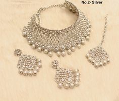 * SIlver choker necklace Set with earrings Tikka as shown in the pic. * Studded with crystals and rhinestones. * One of a Kind. *No.1- Silver *Necklace Width- 1.6 inches(included drops) * Earrings Length: 2.3 inches(included drops) *Earrings Breadth- 1.6 inches *No.2- silver *Necklace Width- 2 inches(included drops) * Earrings Length: 2.6 inches(included drops) *Earrings width- 1.4 inches Silver Festive Choker Jewelry, Silver Choker Jewelry Sets As Gift, Silver Bridal Choker For Festive Occasions, Silver Metal Choker Jewelry Sets, Silver Choker For Celebrations, Silver Round Choker For Celebrations, Silver Metal Jewelry Sets For Celebration, Silver Jewelry Sets For Celebration, Silver Jewelry Sets With Silver Beads As Gift