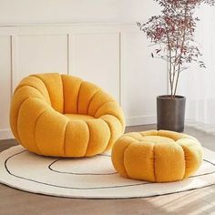 two yellow chairs sitting on top of a rug next to a potted plant in a room