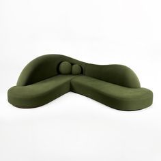 a green couch with two balls on the back and one ball at the end, sitting in front of a white background