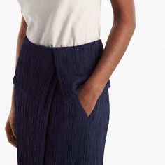 Sizing tip: This skirt runs large. Our stylists recommend ordering one size down. Inspired by classic tuxedo details, this sophisticated skirt features an angular, folded waist detail that creates a peplum-like silhouette. This season, we’ve updated it in a luxurious Italian knit with a pleated texture that allows for shaping and contouring in all the right places. Besom pockets add a little shine, while a secure underlayer keeps you feeling secured and well-covered. Structured Fitted Skirt For Evening, Modern Asymmetrical Skirt For Office, Formal Summer Bottoms With Pleated Waist, Elegant Asymmetrical Voluminous Skirt, Chic Pleated Asymmetrical Draped Skirt, Elegant Pleated Draped Skirt For Summer, Chic Draped Long Skirt With Folds, Elegant Pleated Summer Bottoms, Elegant Structured Lined Skirt