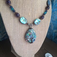 Abalone necklace set shell pendant necklace tree of life boho necklace tribal beach necklace ocean puka surf set unique jewelry for women This beauty has an inlaid puma, abalone and mother of pearl 75mm pendant, with hand wired tree of life, 22mm abalone shell double sided beads, 10mm amethyst gemstone beads, 6mm blue and teal beach glass beads, 5mm rare golden lip oyster puka shell beads, 13 0 seed beads, copper findings and toggle clasp. Length is 22 inches approx. Earrings: 40mm approx with d Hippie Beaded Pendant Jewelry, Hippie Style Beaded Pendant Jewelry, Hippie Festival Jewelry With Natural Stones, Beach Spiritual Hand Wrapped Necklaces, Hand Wrapped Spiritual Necklaces For The Beach, Spiritual Hand Wrapped Necklaces For Beach, Spiritual Hand Wrapped Necklace For Beach, Hippie Festival Jewelry With Unique Variations, Handmade Adjustable Pendant Shell Necklace