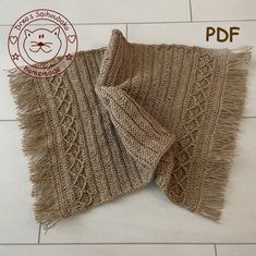 a knitted scarf with fringes on the floor