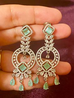 Our Mint CZ Silver finish AD Earrings, the perfect accessory for any Indian outfit or party gown. These earrings have a stunning silver finish, sure to elevate any ensemble. Add a touch of elegance and glamour to your wardrobe with these earrings today. Length - 6 cm Jewellery Care- Keep the jewelry dry, avoid heat and contact with perfumes & water. Jewellery With Gown, Elegant Silver Plug Earrings For Party, Elegant Green Plug Earrings For Party, Hand Set Diamond Drop Earrings For Party, Party Hand Set Diamond Drop Earrings, Party Hand Set Cubic Zirconia Chandelier Earrings, Elegant Hand Set Hoop Earrings For Celebration, Hand Set Cubic Zirconia Earrings For Evening, Elegant Sterling Silver Hoop Earrings For Festive Occasions