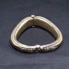 *Description: This is a great embossed design tribal bracelet with a hinge and plunger clasp which makes it very easy to take on and off from the 1940s. The plunger stays attached so you don't have to worry about loosing it. The bracelet has a gold wash, which I tested at 10K gold surface metal. The bracelet under the gold wash is a non-magnetic brass metal; probably mostly hollow. The shape of the bracelet is very unique and is more of a triangular shape with the flat portion on the bottom behi Antique Metal Cuff Bracelet For Ceremonial Use, Antique Metal Cuff Bracelet For Ceremonial Occasions, Antique Jewelry Bangle With Antique Finish, Antique Finish Bangle Jewelry, Antique Engraved Bronze Cuff Bracelet, Heavy Vintage Metal Jewelry, Antique Style Bangle With Antique Finish, Traditional Engraved Collectible Bangle, Antique Bracelet Jewelry For Festivals