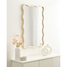 a white dresser with a vase and mirror on it