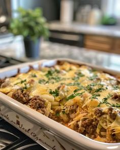 a casserole dish with meat, cheese and onions in it on the stove