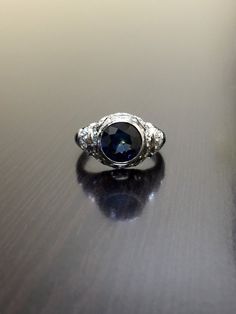 a blue and white diamond ring sitting on top of a table