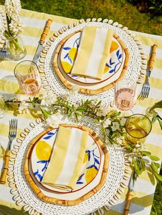 the table is set with yellow and white plates, napkins, and silverware